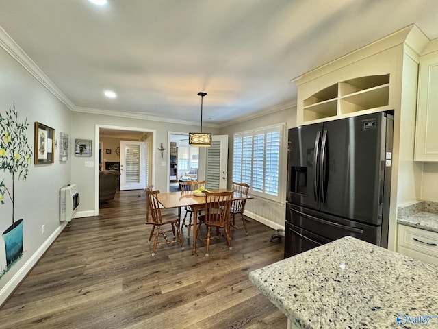 dining space featuring heating unit, crown molding, and dark hardwood / wood-style flooring