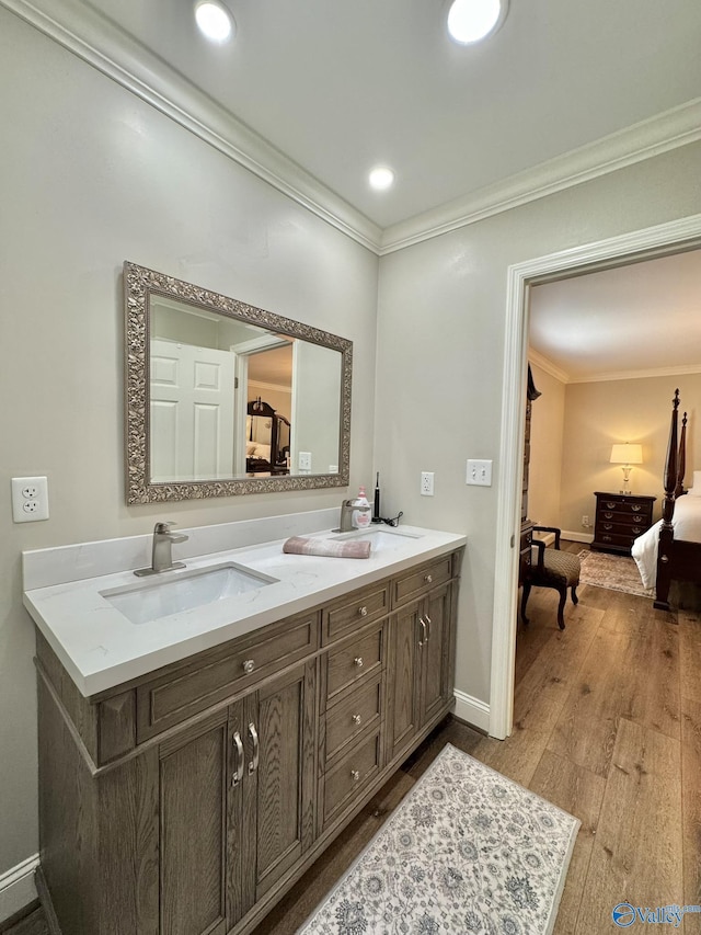 bathroom with hardwood / wood-style floors, crown molding, and vanity