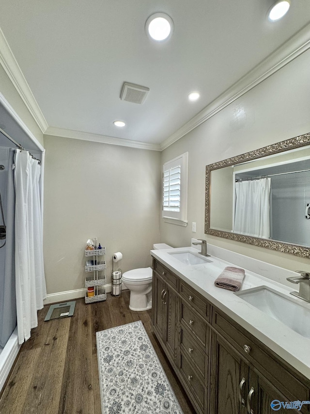 bathroom featuring toilet, ornamental molding, vanity, and wood-type flooring