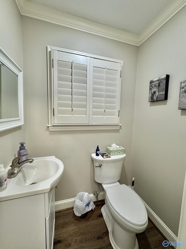 bathroom featuring toilet, vanity, hardwood / wood-style floors, and crown molding