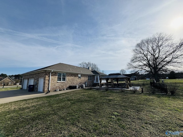 view of side of property with a yard, a garage, and a gazebo