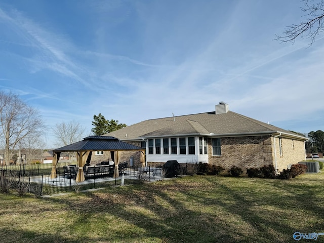 rear view of property with a patio area, a lawn, central air condition unit, and a gazebo