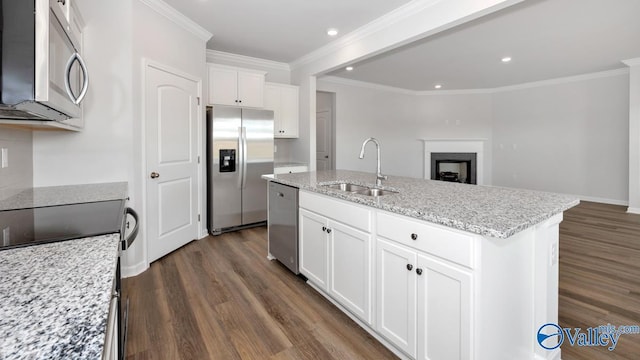 kitchen with light stone countertops, sink, a center island with sink, white cabinets, and appliances with stainless steel finishes