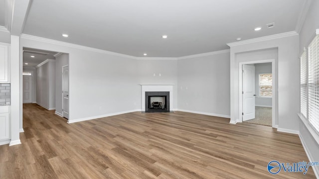 unfurnished living room with light hardwood / wood-style floors and crown molding