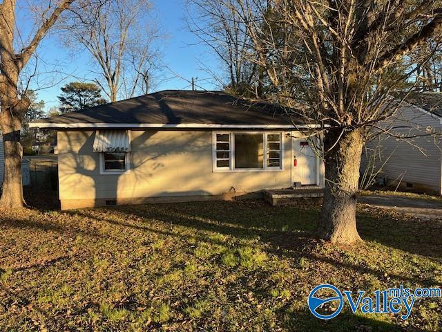 view of side of home featuring crawl space and a yard