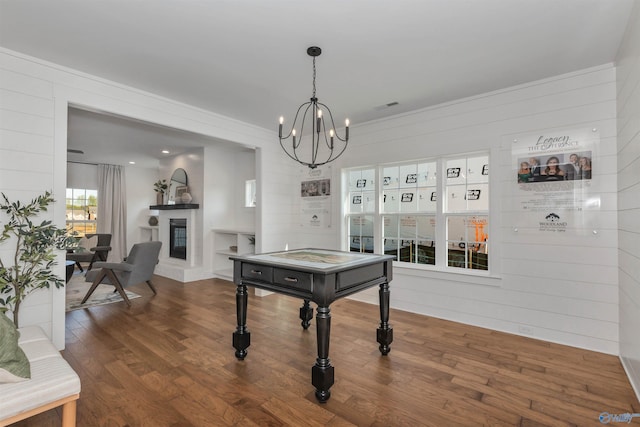 playroom with a notable chandelier, wood walls, and wood-type flooring