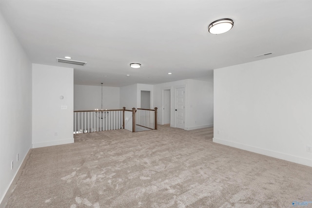 unfurnished room with light carpet and a chandelier