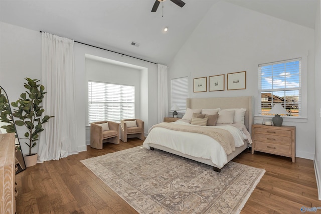 bedroom with ceiling fan, high vaulted ceiling, and dark wood-type flooring