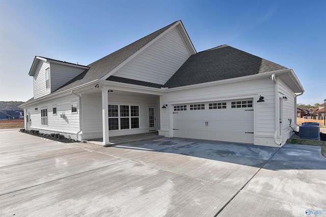 view of front of house featuring a garage and cooling unit