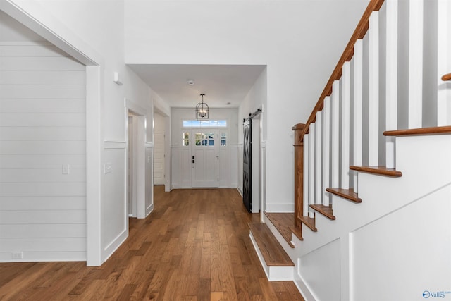 foyer entrance featuring a barn door and wood-type flooring