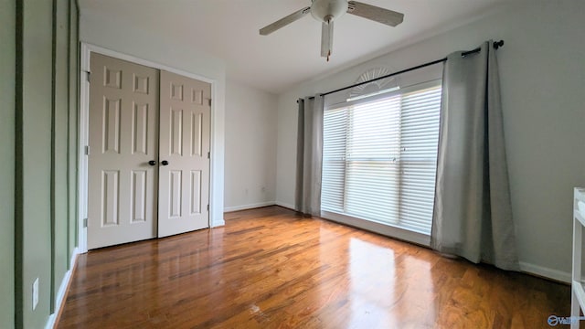 unfurnished bedroom with ceiling fan, a closet, and wood-type flooring