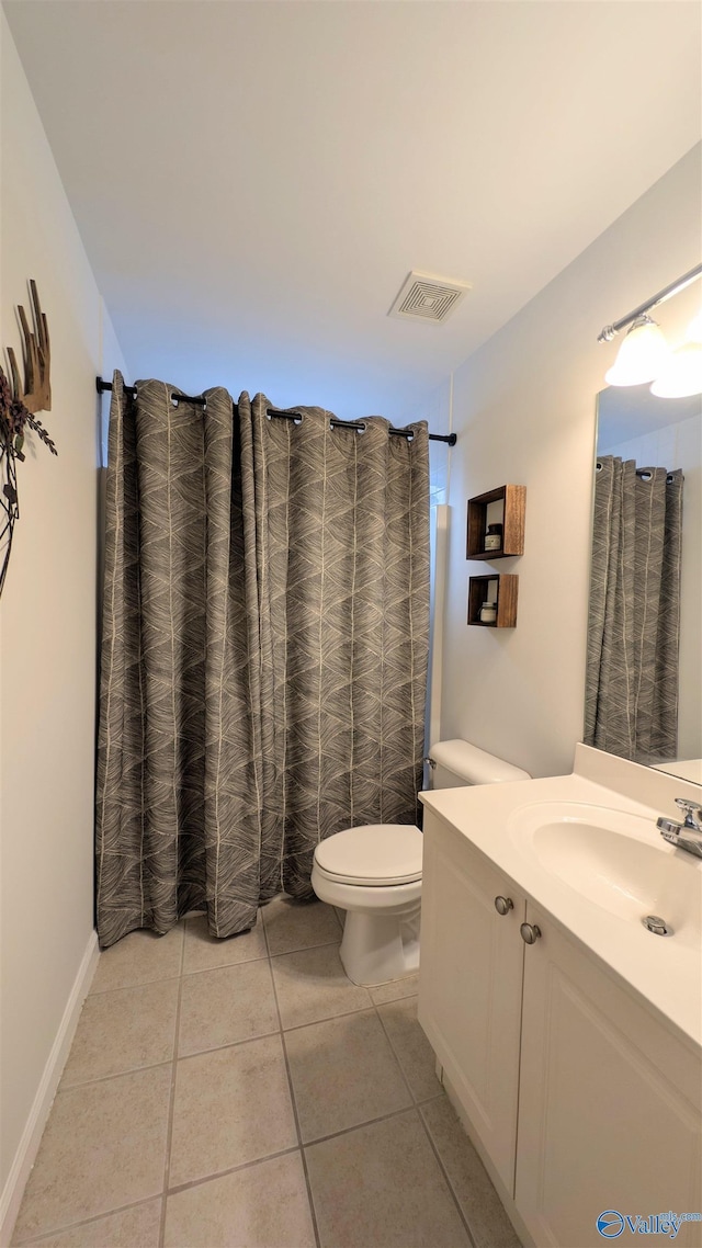 bathroom featuring tile patterned flooring, vanity, and toilet