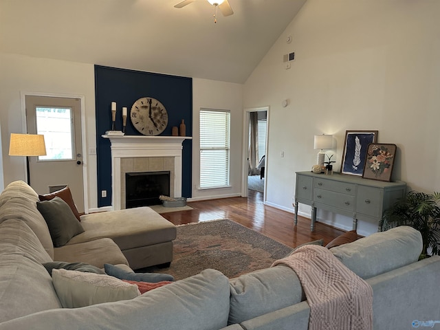 living room with a fireplace, hardwood / wood-style floors, high vaulted ceiling, and ceiling fan