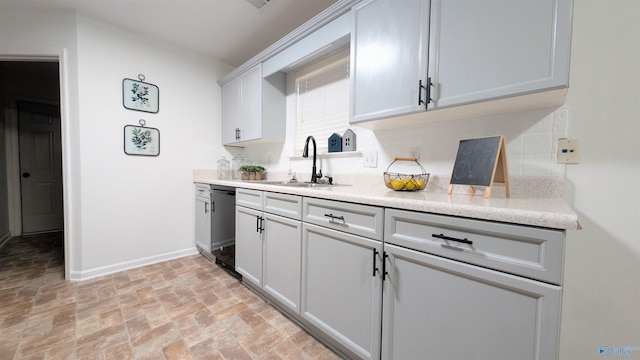 kitchen with tasteful backsplash, sink, and black dishwasher