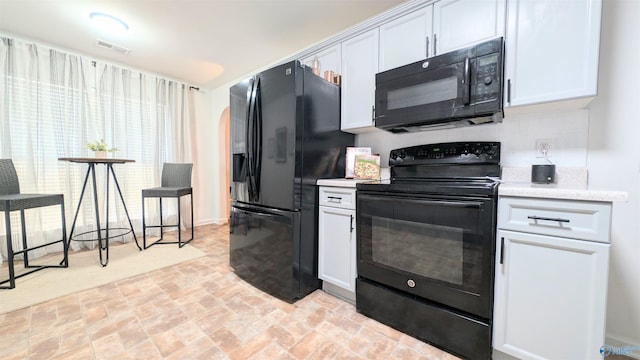 kitchen with decorative backsplash, white cabinets, and black appliances