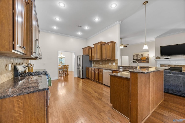 105 Cherrywood Dr, Madison, AL 35756 - kitchen featuring appliances with stainless steel finishes, brown cabinetry, ornamental molding, open floor plan, and a peninsula