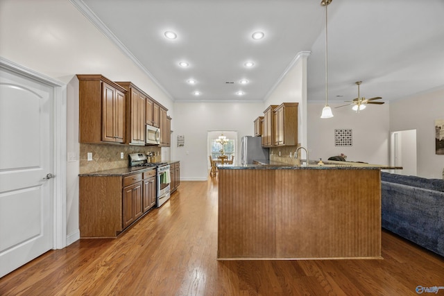 105 Cherrywood Dr, Madison, AL 35756 - kitchen featuring stainless steel appliances, open floor plan, crown molding, brown cabinets, and backsplash
