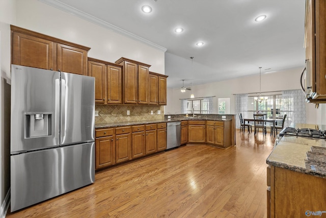 105 Cherrywood Dr, Madison, AL 35756 - kitchen with appliances with stainless steel finishes, a peninsula, brown cabinetry, light wood-style flooring, and recessed lighting
