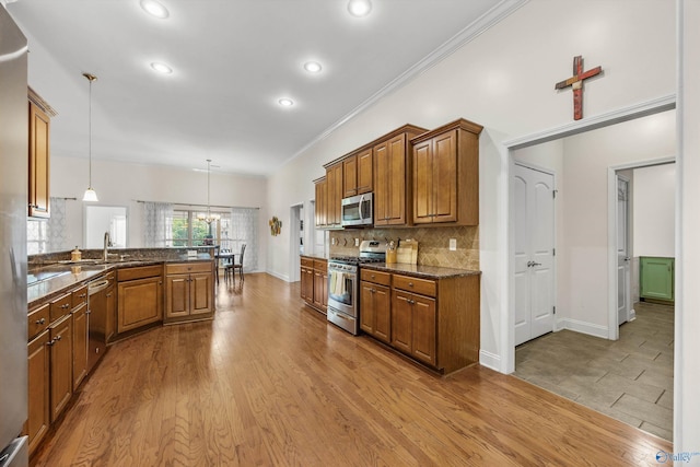 105 Cherrywood Dr, Madison, AL 35756 - kitchen with stainless steel appliances, brown cabinets, tasteful backsplash, decorative light fixtures, and recessed lighting
