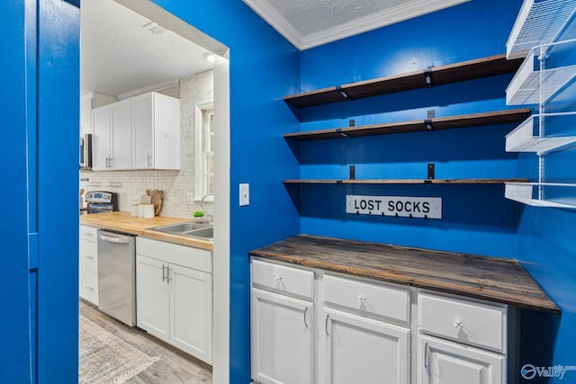 kitchen featuring light wood-type flooring, white cabinets, sink, dishwasher, and butcher block counters