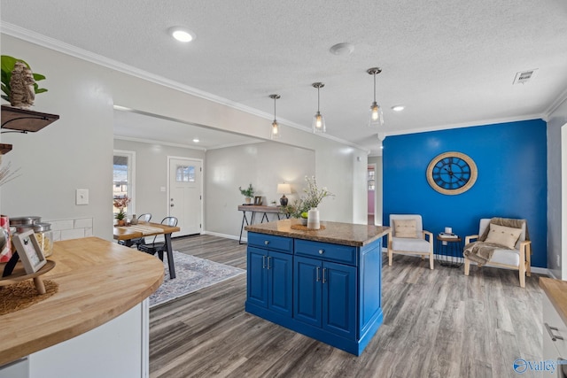 kitchen with blue cabinets, dark hardwood / wood-style floors, decorative light fixtures, and ornamental molding