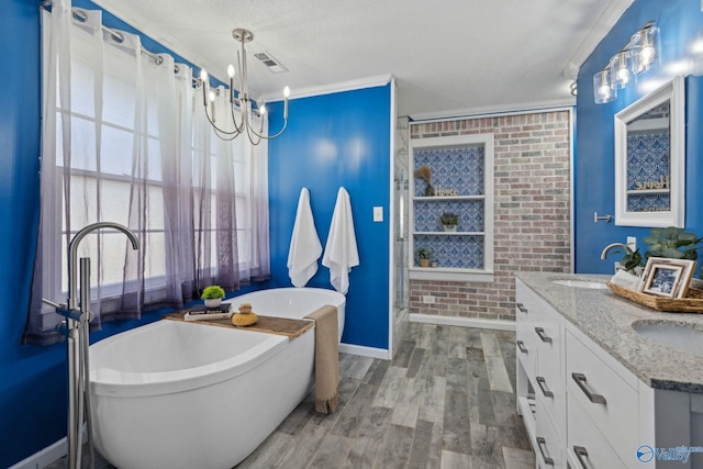 bathroom with a tub to relax in, crown molding, a textured ceiling, vanity, and hardwood / wood-style flooring