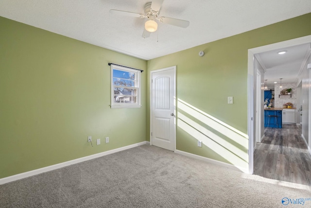 carpeted empty room featuring ceiling fan