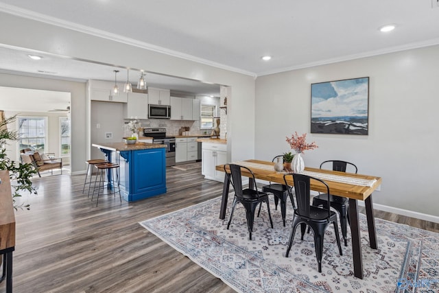 dining space featuring hardwood / wood-style floors, ceiling fan, and crown molding