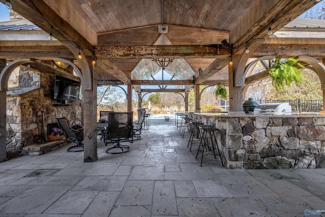 view of patio featuring outdoor wet bar, exterior kitchen, and grilling area