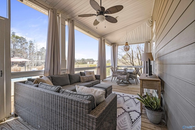 sunroom / solarium featuring wood ceiling, a ceiling fan, and vaulted ceiling