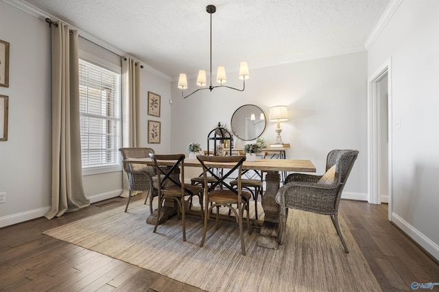 dining space with a textured ceiling, a notable chandelier, crown molding, and hardwood / wood-style flooring