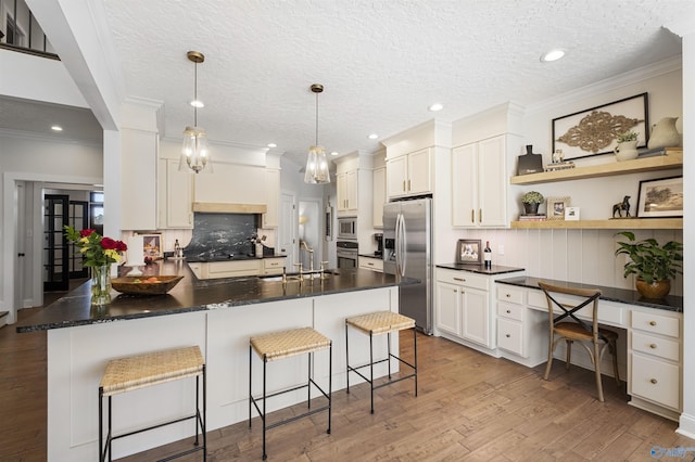 kitchen featuring a sink, dark countertops, appliances with stainless steel finishes, and built in study area