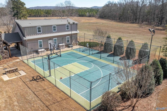 view of basketball court featuring a tennis court, community basketball court, and fence