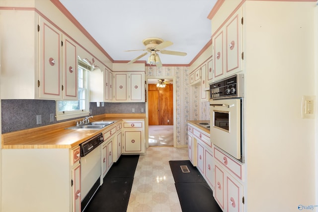 kitchen with ornamental molding, a ceiling fan, a sink, white appliances, and wallpapered walls