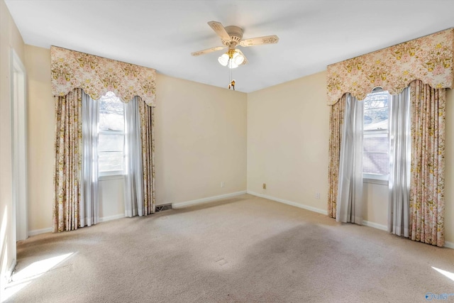 spare room featuring carpet, ceiling fan, and plenty of natural light