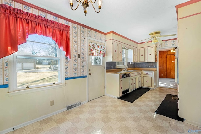 kitchen with wallpapered walls, dishwasher, a wainscoted wall, light floors, and a sink