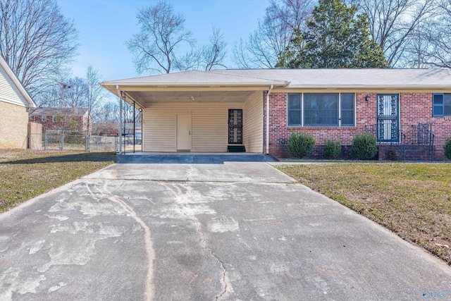 single story home featuring driveway, an attached carport, fence, a front lawn, and brick siding