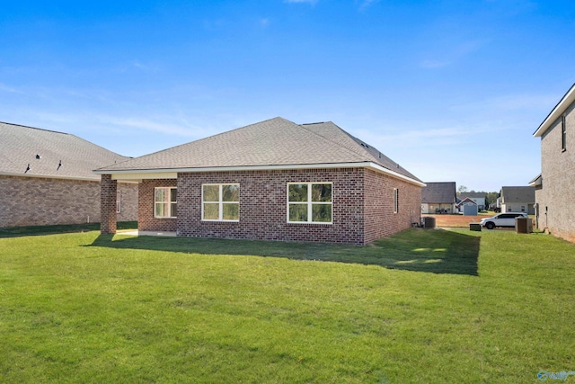 rear view of house with a lawn and central air condition unit