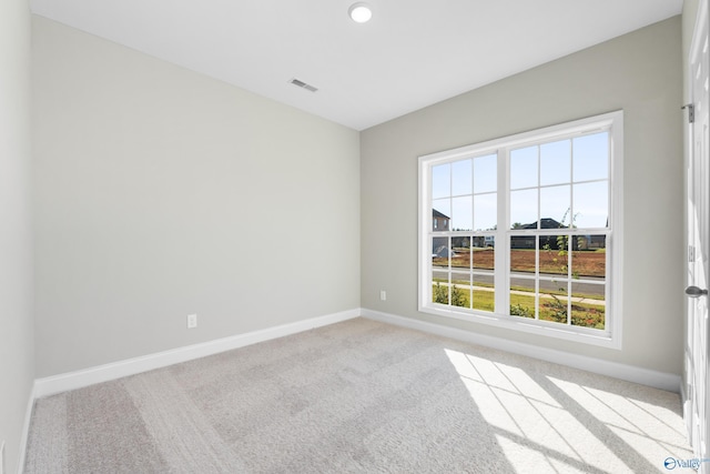 unfurnished room featuring light carpet