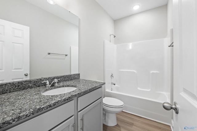 full bathroom with vanity, wood-type flooring, shower / tub combination, and toilet