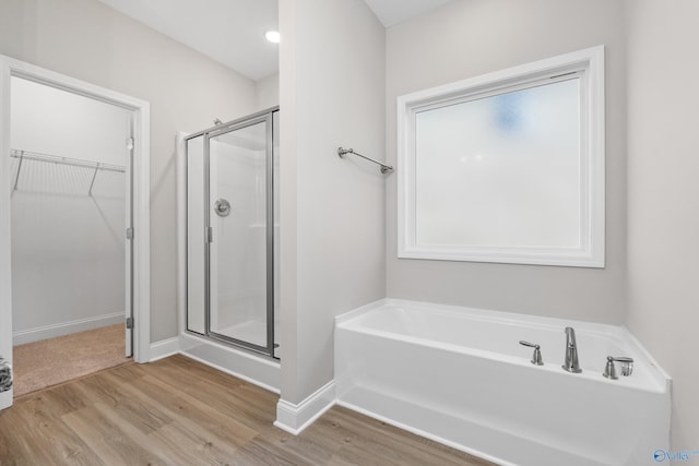 bathroom featuring independent shower and bath and hardwood / wood-style floors