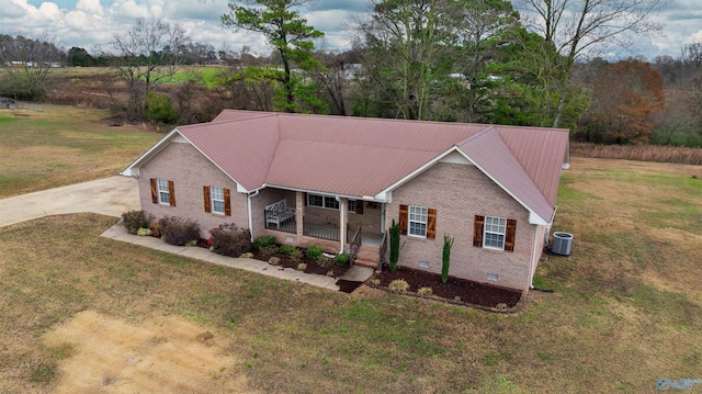 view of front of home with a front lawn, central AC unit, and a porch