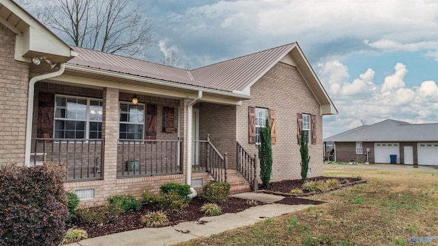 view of front of home with an outbuilding, a porch, a garage, and a front yard