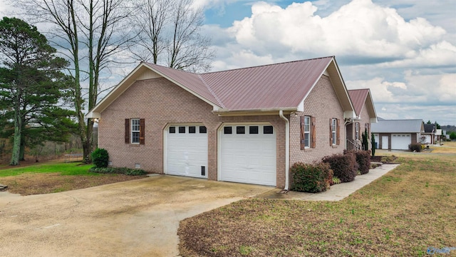 view of side of property featuring a garage and a lawn