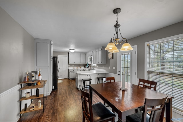 dining space featuring dark hardwood / wood-style flooring, a notable chandelier, and sink