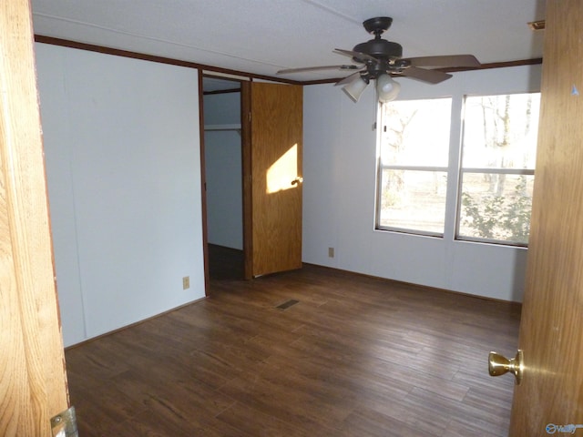 unfurnished bedroom with ceiling fan, dark hardwood / wood-style floors, and a closet