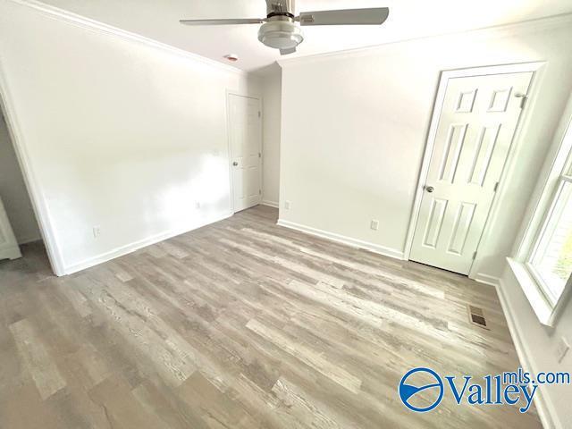 2618 NW Mountain Park Cir, Huntsville, AL 35810 - unfurnished bedroom with crown molding, wood finished floors, and ceiling fan