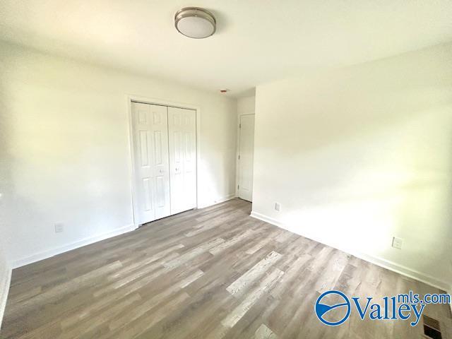 2618 NW Mountain Park Cir, Huntsville, AL 35810 - unfurnished bedroom with wood finished floors and a closet