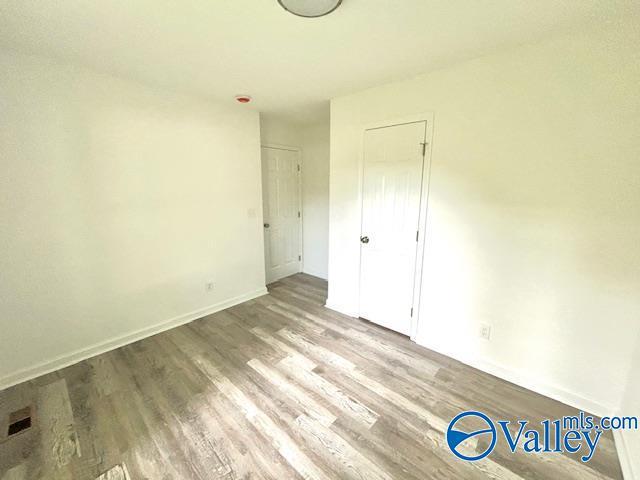 2618 NW Mountain Park Cir, Huntsville, AL 35810 - unfurnished bedroom with wood finished floors and baseboards