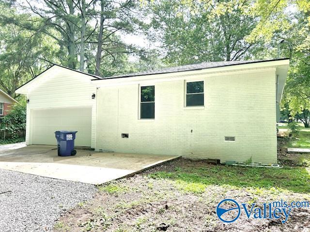 2618 NW Mountain Park Cir, Huntsville, AL 35810 - rear view of property with crawl space, an attached garage, concrete driveway, and brick siding